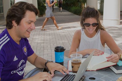 two law students sitting at a table outside