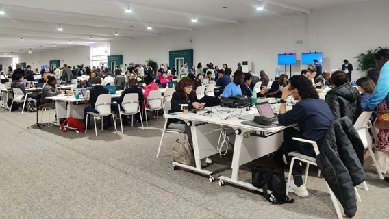 People working on laptops at the COP 29 computer center